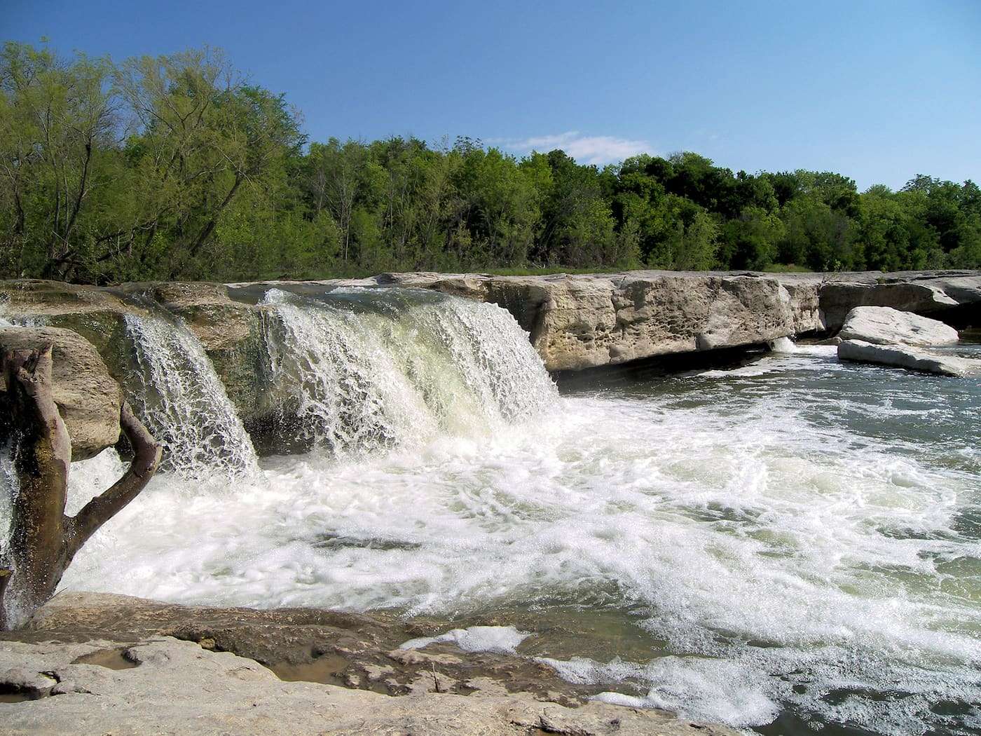 The water of Onion Creek, a tributary of the Colorado River, goes over the lower falls at McKinney Falls State Park . The limestone above the falls is documente