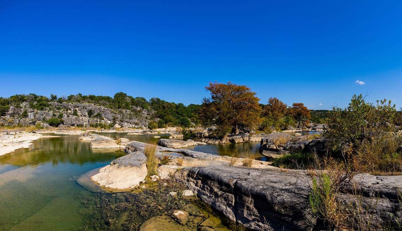 Just the slightest of red starting to come through on these cypress trees in the middle of the Pedernales river in Pedernales Falls State Park, Texas.